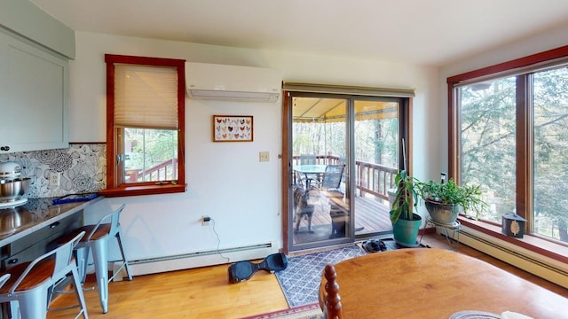 823 Grindstone Rd, Medway, ME 04460 - dining space featuring a baseboard heating unit, a wall mounted air conditioner, and plenty of natural light