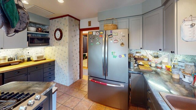823 Grindstone Rd, Medway, ME 04460 - kitchen featuring stainless steel appliances, tasteful backsplash, light tile patterned floors, gray cabinetry, and a sink