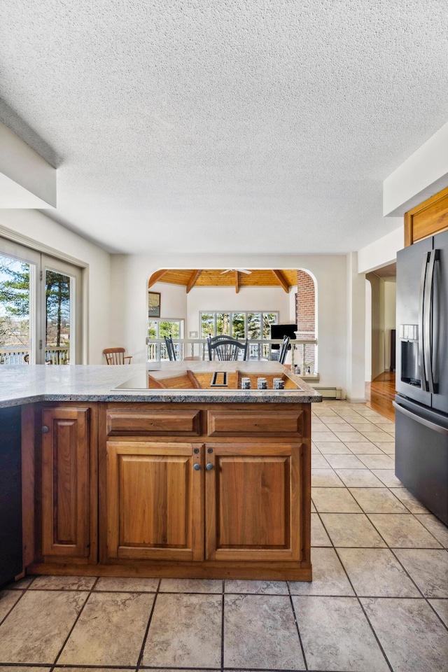 126 Middle Rd, Woolwich, ME 04579 - kitchen with brown cabinetry, a textured ceiling, light tile patterned flooring, and stainless steel fridge with ice dispenser