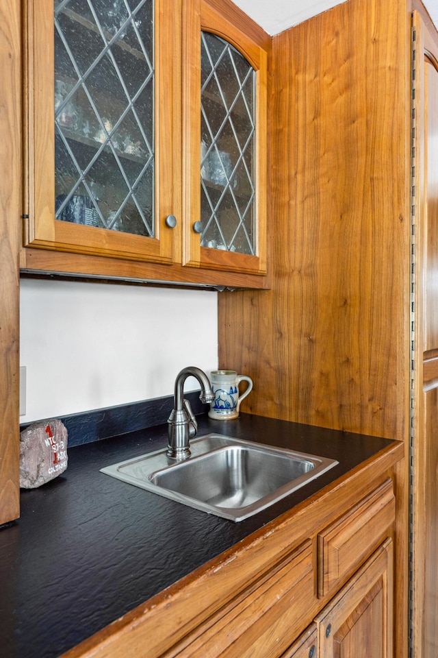 126 Middle Rd, Woolwich, ME 04579 - kitchen with dark countertops, glass insert cabinets, a sink, and brown cabinetry