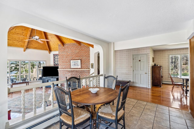 126 Middle Rd, Woolwich, ME 04579 - dining area with a brick fireplace, brick wall, ceiling fan, vaulted ceiling with beams, and arched walkways