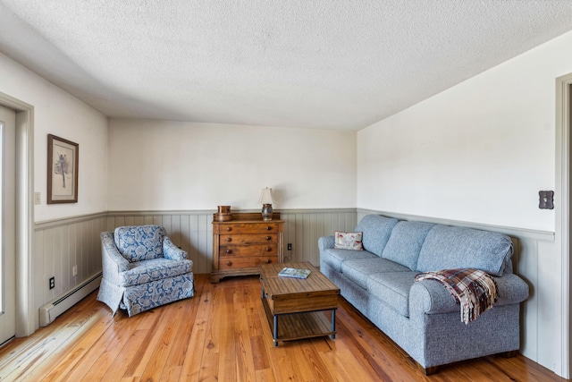 126 Middle Rd, Woolwich, ME 04579 - living room featuring a textured ceiling, wainscoting, baseboard heating, and hardwood / wood-style flooring