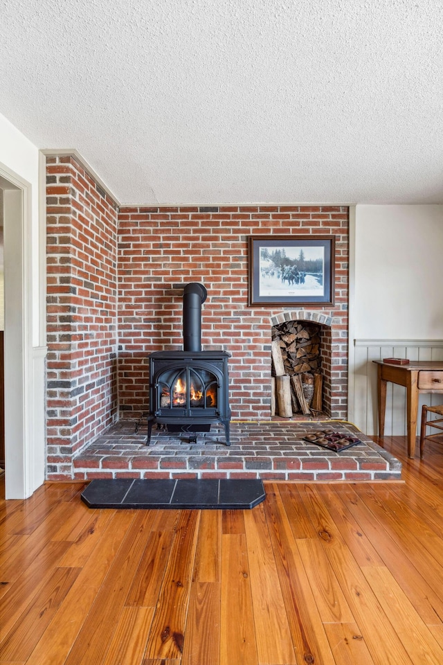 126 Middle Rd, Woolwich, ME 04579 - unfurnished living room with a textured ceiling, a wood stove, and hardwood / wood-style floors