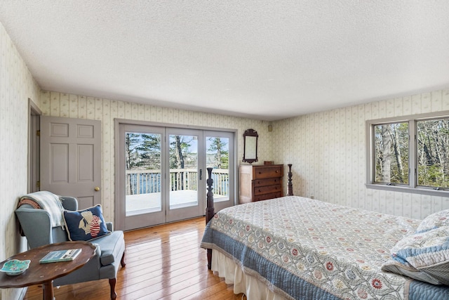 126 Middle Rd, Woolwich, ME 04579 - bedroom featuring access to outside, a textured ceiling, multiple windows, and light wood-type flooring