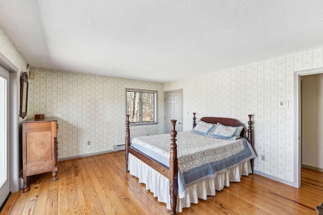 126 Middle Rd, Woolwich, ME 04579 - bedroom with a textured ceiling, wallpapered walls, and light wood-style flooring