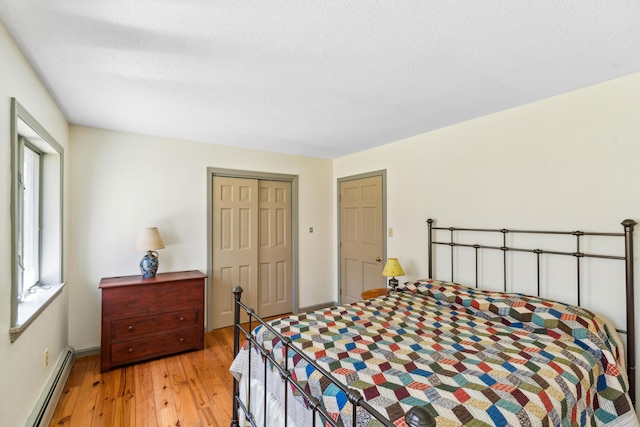 126 Middle Rd, Woolwich, ME 04579 - bedroom with a closet, baseboards, light wood-style flooring, and a baseboard radiator