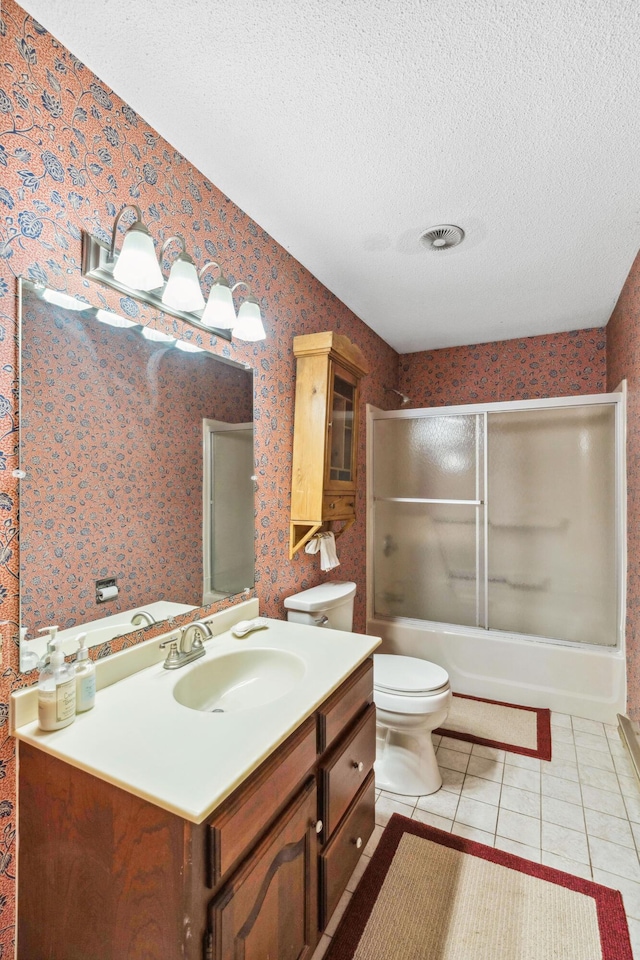 126 Middle Rd, Woolwich, ME 04579 - bathroom featuring tile patterned flooring, shower / bath combination with glass door, toilet, wallpapered walls, and a textured ceiling