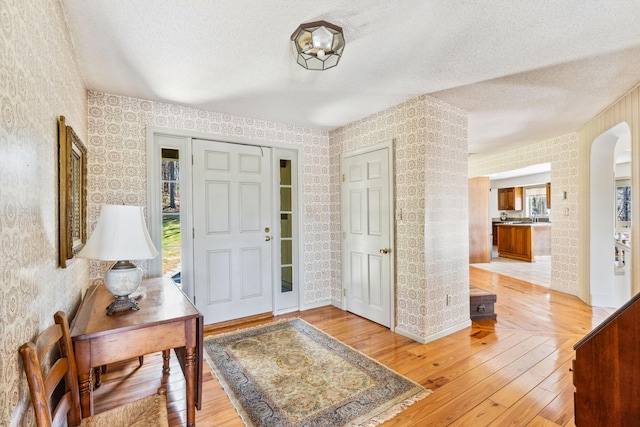 126 Middle Rd, Woolwich, ME 04579 - foyer entrance featuring light wood-style floors, plenty of natural light, wallpapered walls, and a textured ceiling