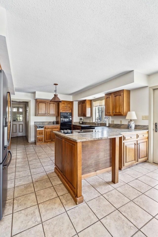 126 Middle Rd, Woolwich, ME 04579 - kitchen featuring a healthy amount of sunlight, brown cabinets, stainless steel refrigerator with ice dispenser, and a textured ceiling