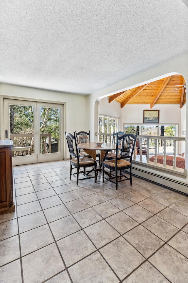 126 Middle Rd, Woolwich, ME 04579 - dining area featuring arched walkways, a textured ceiling, lofted ceiling with beams, and light tile patterned floors