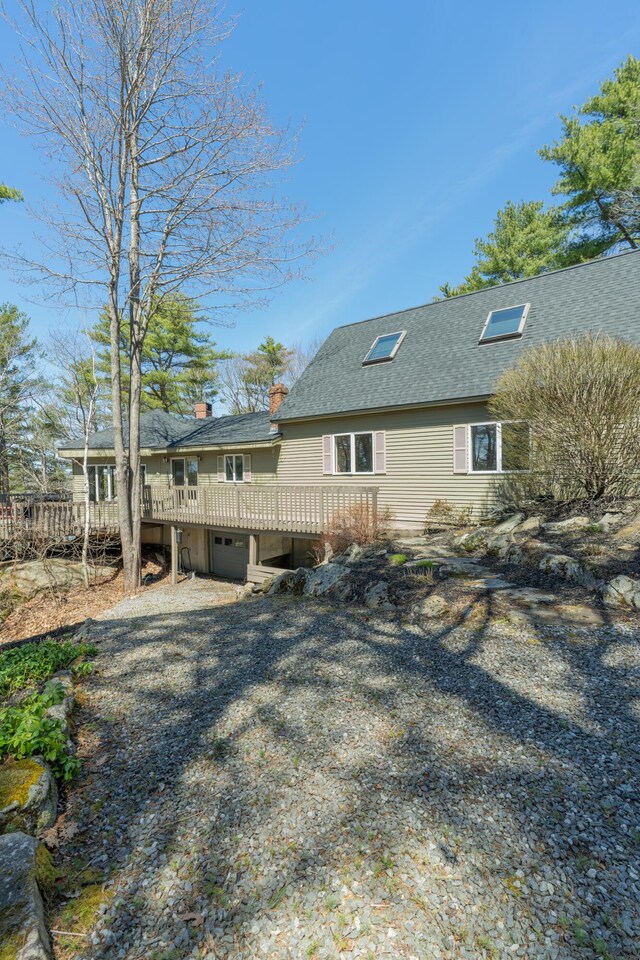 126 Middle Rd, Woolwich, ME 04579 - rear view of house featuring a chimney, a shingled roof, an attached garage, and a deck