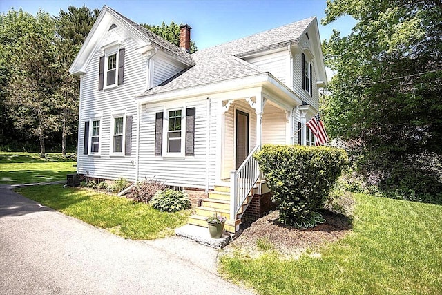 22 Mills Rd, Newcastle, ME 04553 - view of front of house with a chimney, roof with shingles, a front lawn, and covered porch