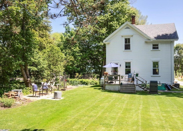 22 Mills Rd, Newcastle, ME 04553 - rear view of house featuring a wooden deck, roof with shingles, a chimney, and a lawn