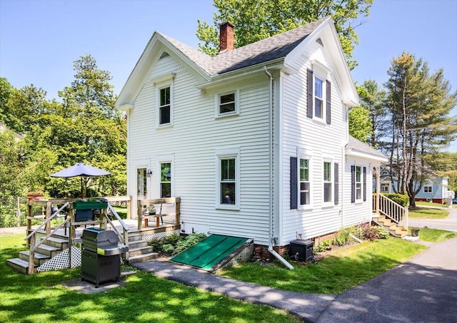 22 Mills Rd, Newcastle, ME 04553 - view of home's exterior featuring a chimney, a yard, a shingled roof, and a wooden deck