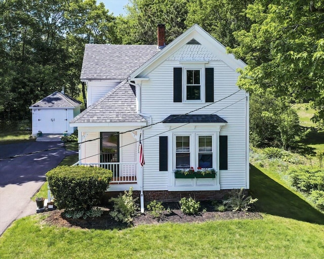 22 Mills Rd, Newcastle, ME 04553 - view of front of home with an outdoor structure, roof with shingles, asphalt driveway, a front yard, and a chimney
