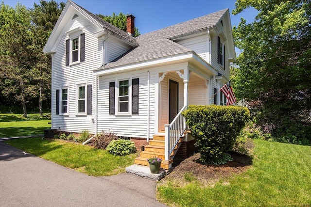 22 Mills Rd, Newcastle, ME 04553 - view of front of property featuring roof with shingles, a chimney, a front lawn, and covered porch