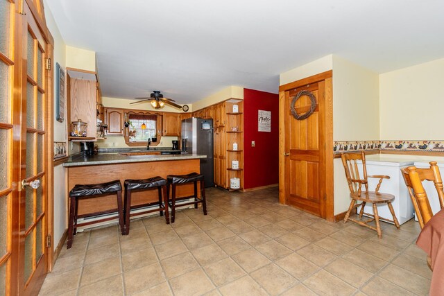 129 Bailey Hill Rd, New Sharon, ME 04955 - kitchen with a sink, a peninsula, stainless steel fridge, brown cabinetry, and ceiling fan