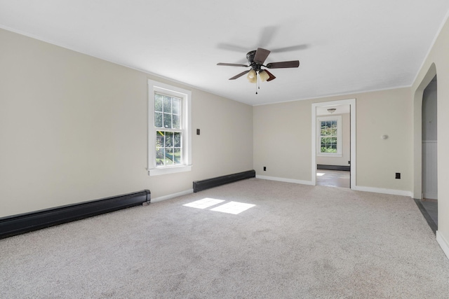 empty room with baseboards, a ceiling fan, arched walkways, and light carpet
