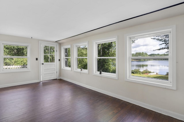 unfurnished sunroom with a healthy amount of sunlight and a water view
