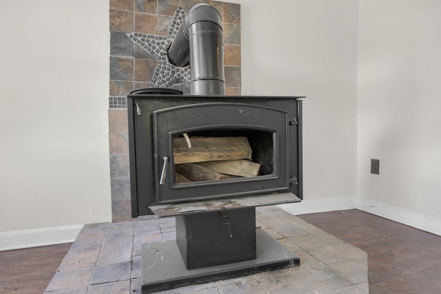 details with a wood stove, wood finished floors, and baseboards