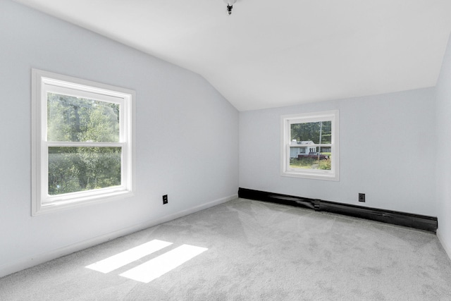 interior space featuring baseboards, vaulted ceiling, carpet, and plenty of natural light