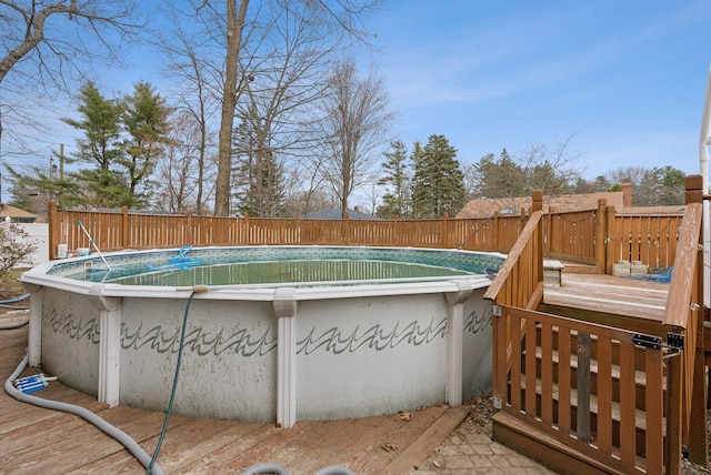 view of swimming pool with a wooden deck, a fenced in pool, and a fenced backyard