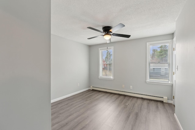 unfurnished room featuring a textured ceiling, baseboards, a ceiling fan, wood finished floors, and a baseboard radiator