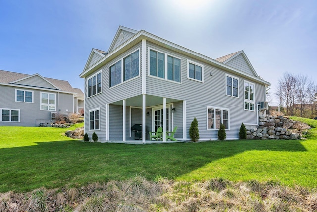 rear view of property featuring a patio and a lawn