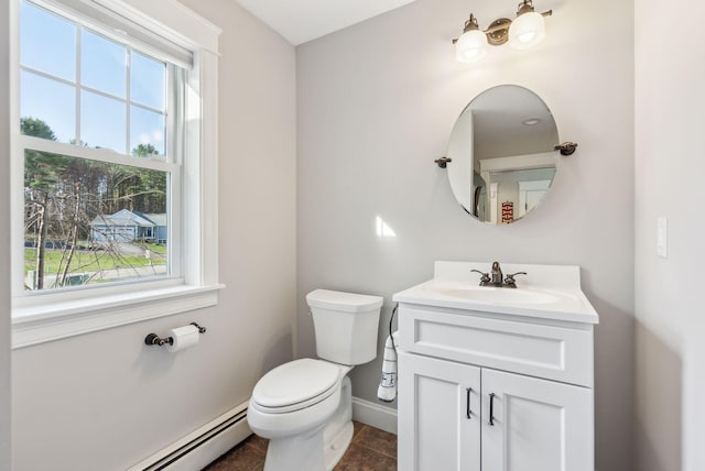 half bath with a healthy amount of sunlight, baseboards, baseboard heating, and toilet