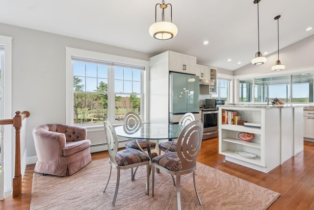 dining space featuring baseboard heating, recessed lighting, wood finished floors, and lofted ceiling