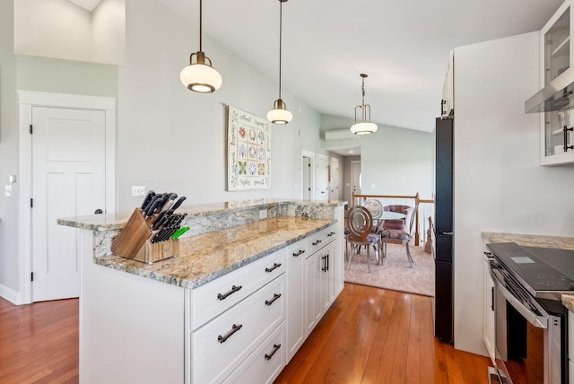 kitchen with white cabinets, fridge, dark wood-type flooring, a kitchen island, and stainless steel electric stove