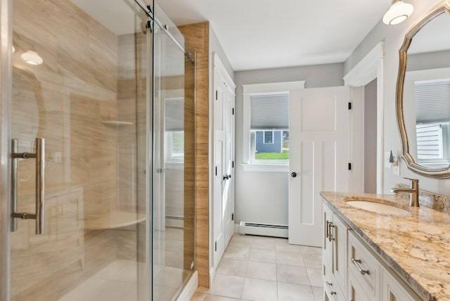 full bath featuring tile patterned flooring, vanity, baseboard heating, a shower stall, and a wealth of natural light