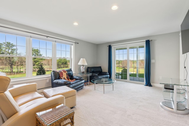 carpeted living area with a baseboard heating unit and recessed lighting