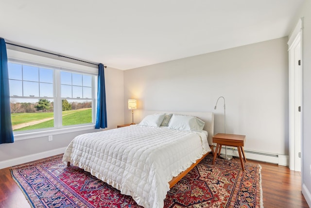 bedroom featuring baseboards, a baseboard radiator, and wood finished floors