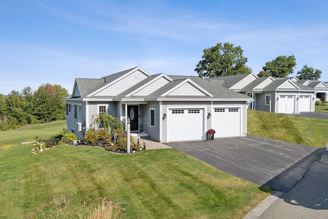 view of front facade featuring an attached garage, a front yard, and aphalt driveway