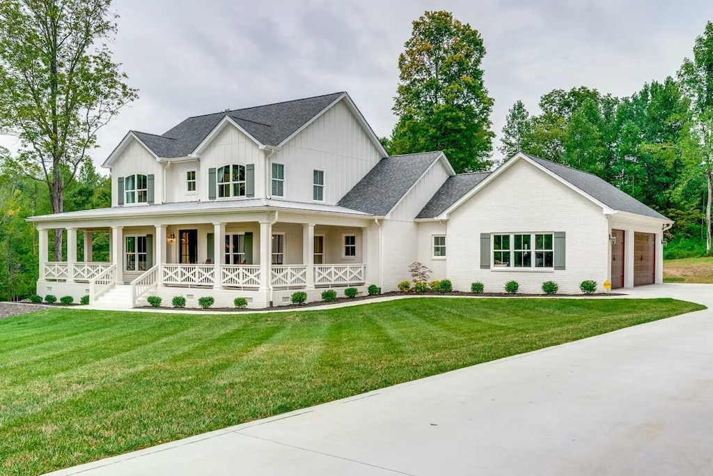 modern inspired farmhouse featuring board and batten siding, driveway, a front lawn, and covered porch
