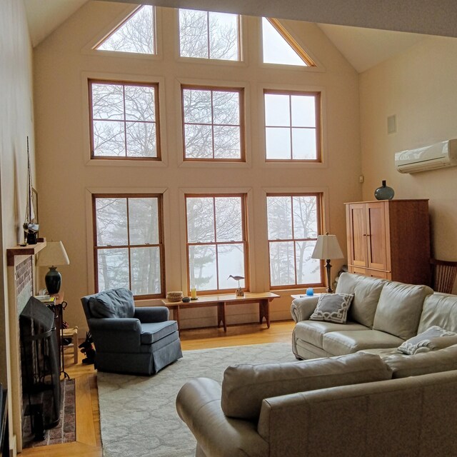 5 Southernpoint Rd, Bristol, ME 04564 - living room featuring a wall mounted AC, high vaulted ceiling, light wood-type flooring, and a fireplace