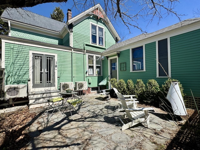 14 Water St, Vinalhaven, ME 04863 - back of property featuring entry steps, a patio area, a chimney, and french doors