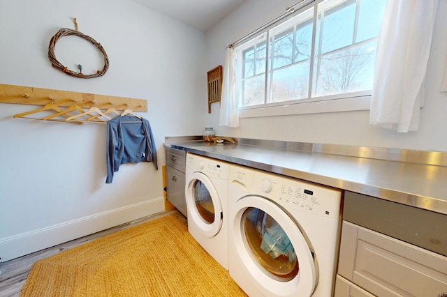 14 Water St, Vinalhaven, ME 04863 - clothes washing area with cabinet space, light wood finished floors, washing machine and clothes dryer, and baseboards