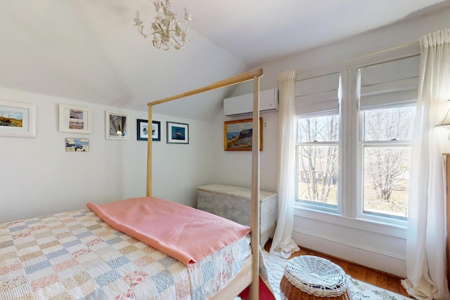 14 Water St, Vinalhaven, ME 04863 - bedroom with a wall mounted air conditioner, lofted ceiling, wood finished floors, and an inviting chandelier