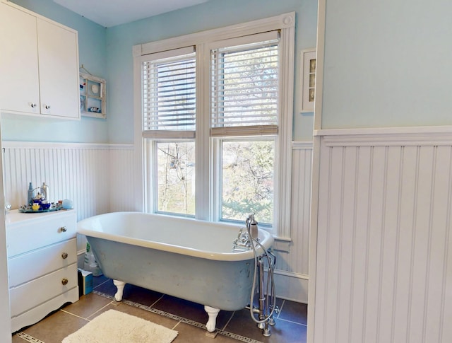 14 Water St, Vinalhaven, ME 04863 - bathroom with wainscoting, tile patterned floors, a decorative wall, and a soaking tub