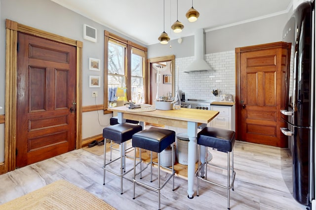 14 Water St, Vinalhaven, ME 04863 - kitchen with backsplash, wall chimney range hood, visible vents, freestanding refrigerator, and pendant lighting