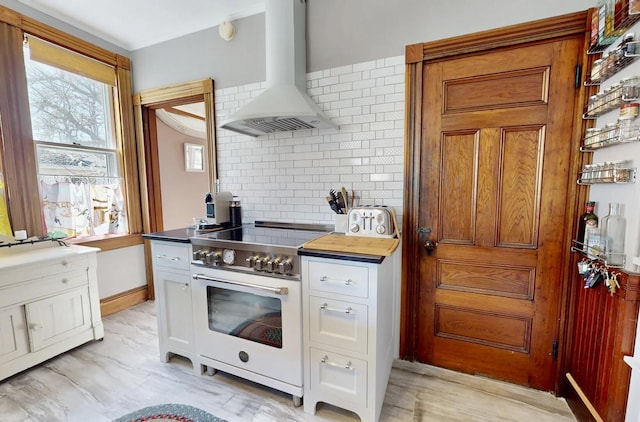 14 Water St, Vinalhaven, ME 04863 - kitchen with backsplash, wall chimney exhaust hood, brown cabinets, and electric range
