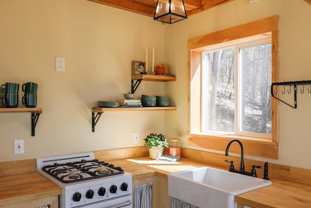 1 Good Day Dr, South Bristol, ME 04568 - kitchen featuring butcher block counters, open shelves, white range with gas cooktop, and a sink