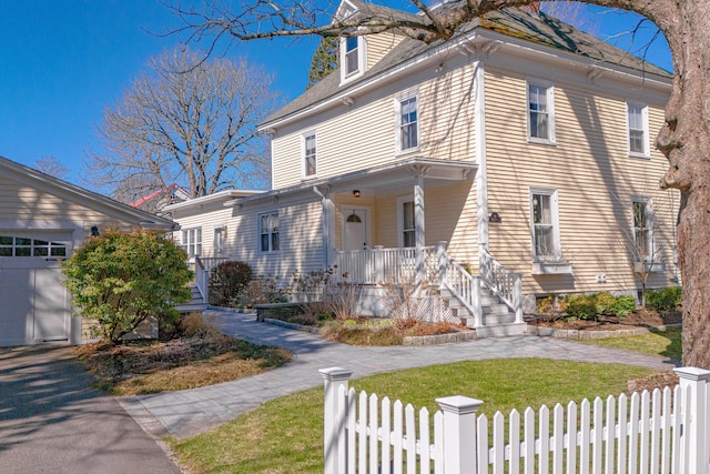 view of front of house with a garage, a porch, and a fenced front yard