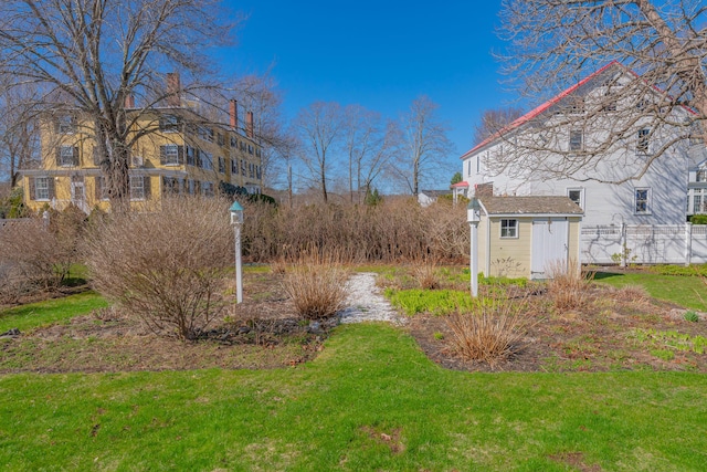 view of yard with an outdoor structure, a storage unit, and fence