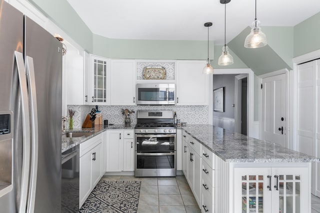 kitchen with tasteful backsplash, a sink, glass insert cabinets, a peninsula, and appliances with stainless steel finishes
