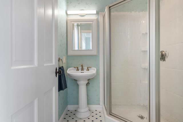 bathroom with baseboards and a stall shower