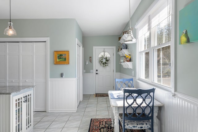 interior space with a wealth of natural light, light tile patterned floors, and wainscoting