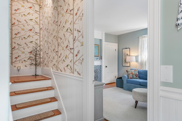 staircase with wainscoting and carpet